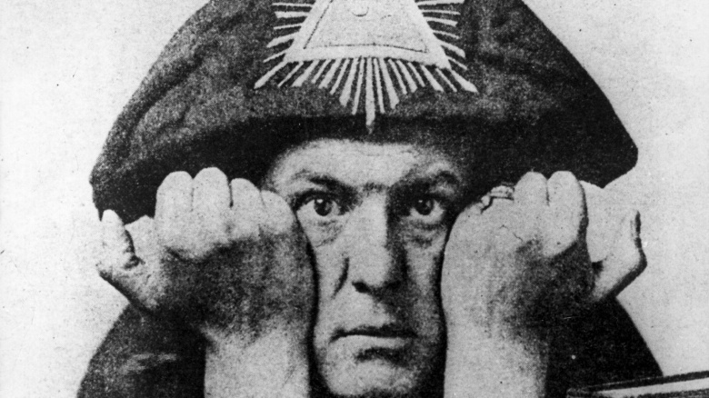 Aleister Crowley with hands on face