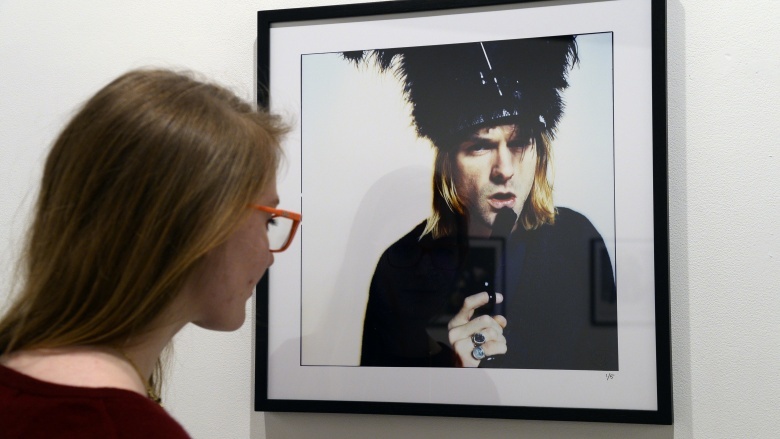 woman looking at Kurt Cobain photograph