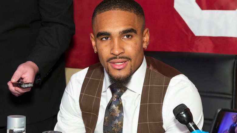 Jalen Hurts speaks at a press conference in a fancy vest and tie