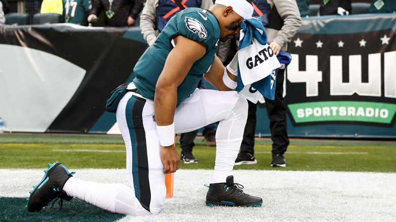 Jalen Hurts kneels on the Eagles' field 