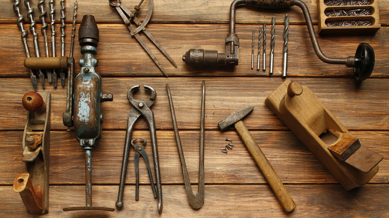 Vintage woodworking tools on wood background, overhead view.