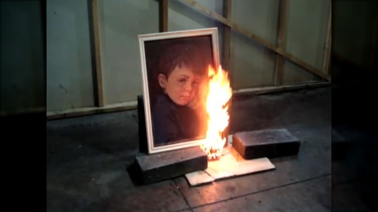 Image of crying boy painting on fire during test