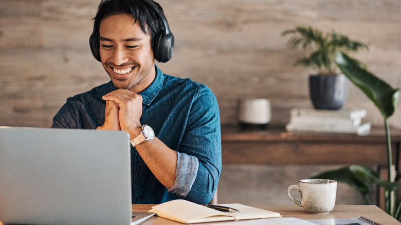 person listening ot headphones on the computer