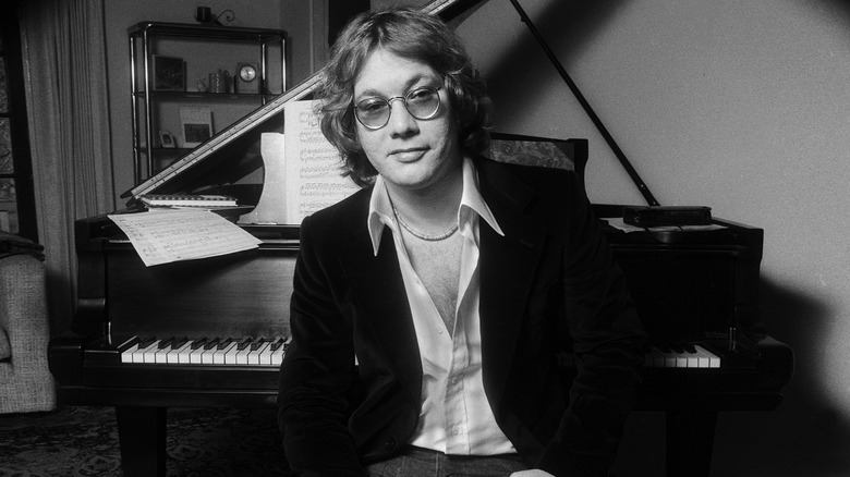 Warren Zevon posing while seated at piano