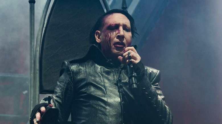 marilyn manson sits on black throne during 2017 concert