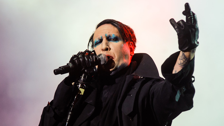 marilyn manson singing and holding up his arm in 2018