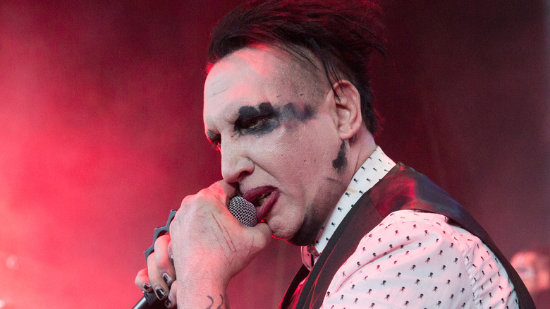 marilyn manson sneering while singing into microphone