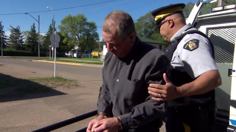 Gerald Stanley in handcuffs being escorted by an officer