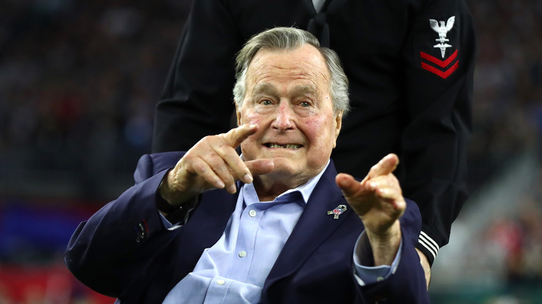 An elderly George H.W. Bush smiling and pointing