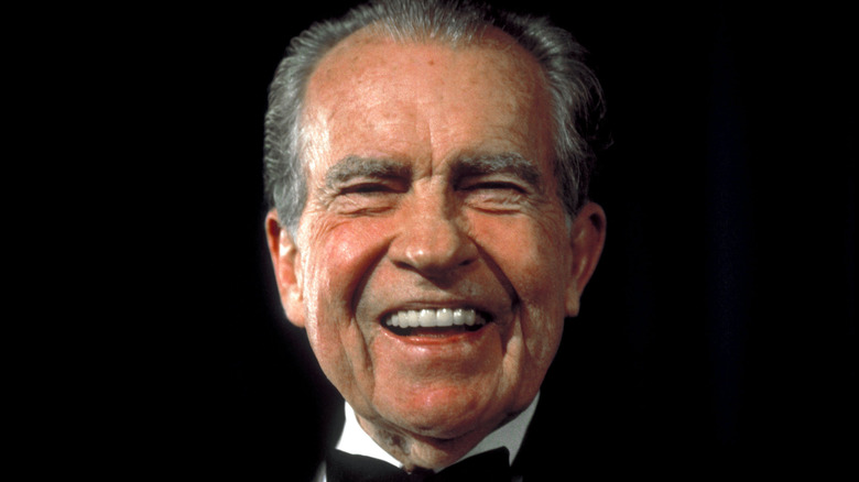 Richard Nixon in a tuxedo flashing a big smile