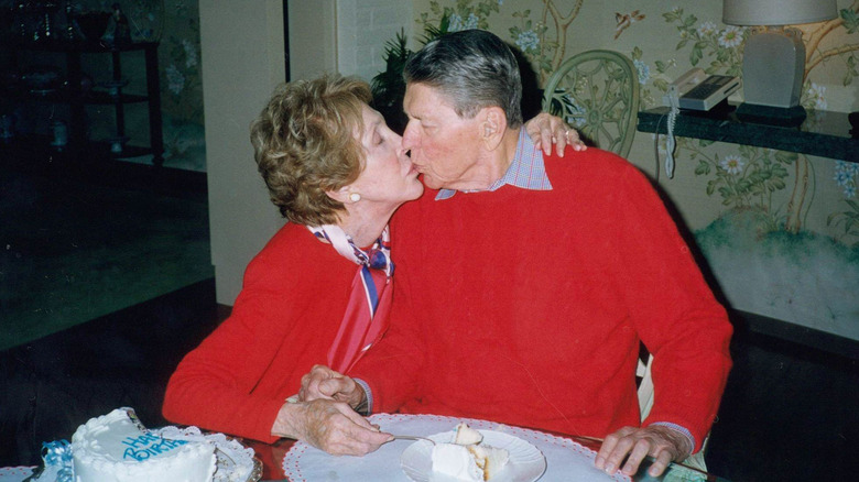 An elderly Ronald and Nancy Reagan kissing at their home