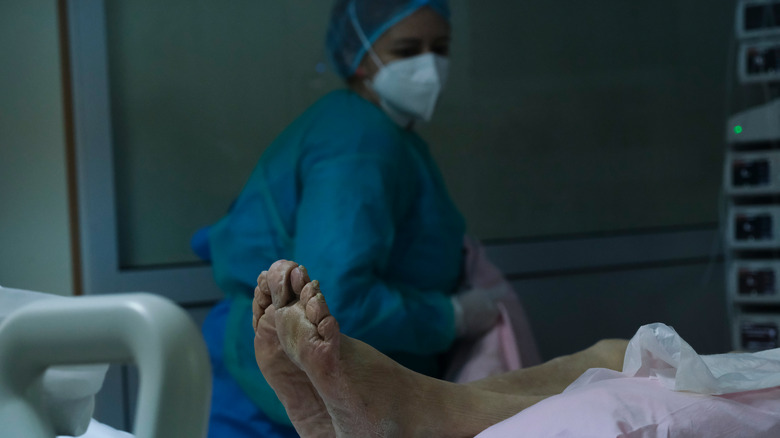 doctor stands in front of corpse