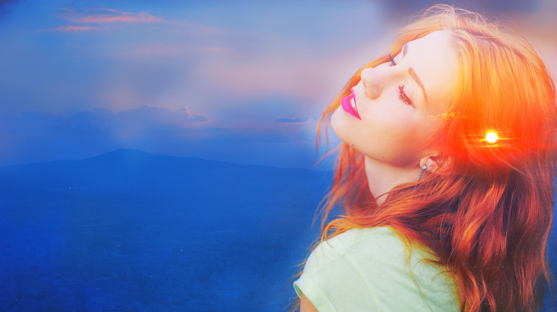 woman redhead smiling with glowing head blue landscape