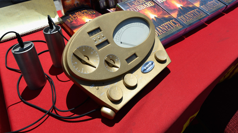 Scientology's gold E-meter sitting on red desk