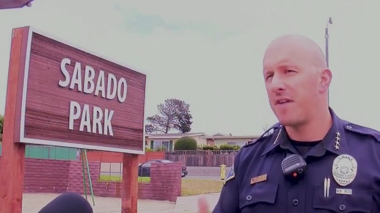 Police officer speaking next to Sabado Park