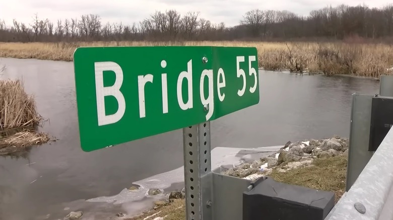 Sign reading Bridge 55 by river