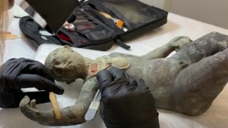 scientist cleaning up Etruscan statue 