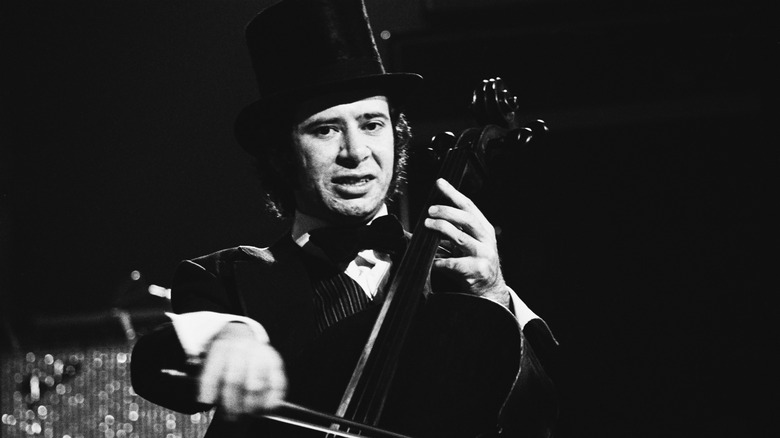 Mike Edwards in a top hat playing the cello