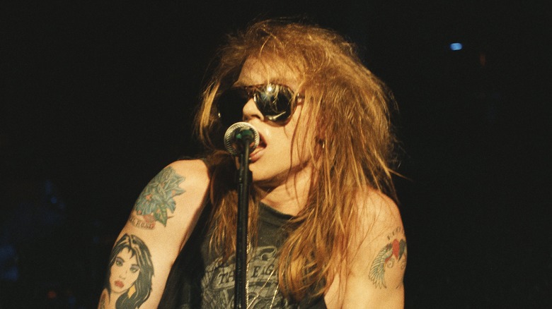 Axl Rose singing on stage sunglasses