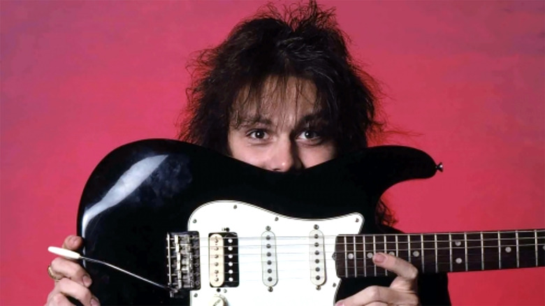 Yngwie Malmsteen hiding behind guitar