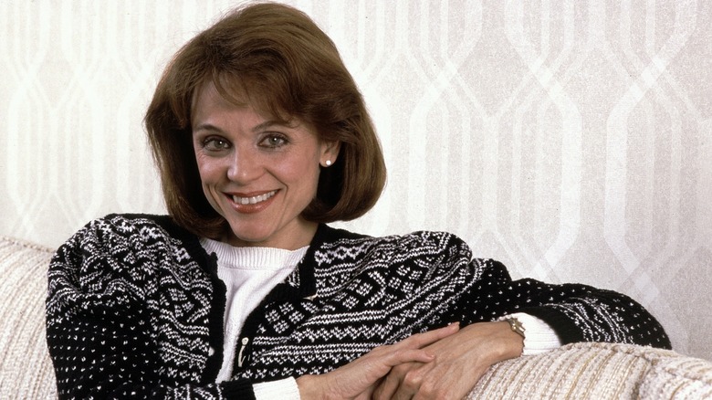 Valerie Harper on couch smiling