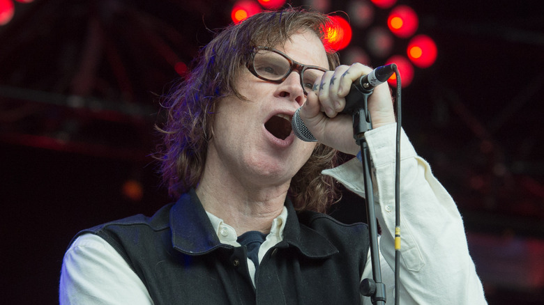 Mark Lanegan singing on stage with red lights