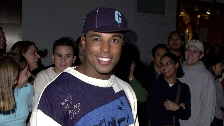 Merlin Santana smiling in a hat at a party