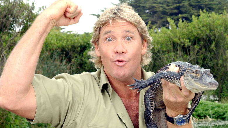 Steve Irwin fist raised holding a small crocodile