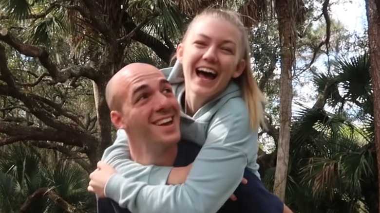 Gabby Petito smiling while riding on Brian Laundrie's shoulders