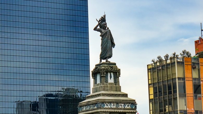 statue of Cuauhtémoc in front of skyscraper