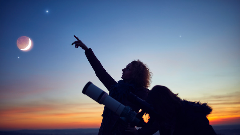 two astronomers using a telescope