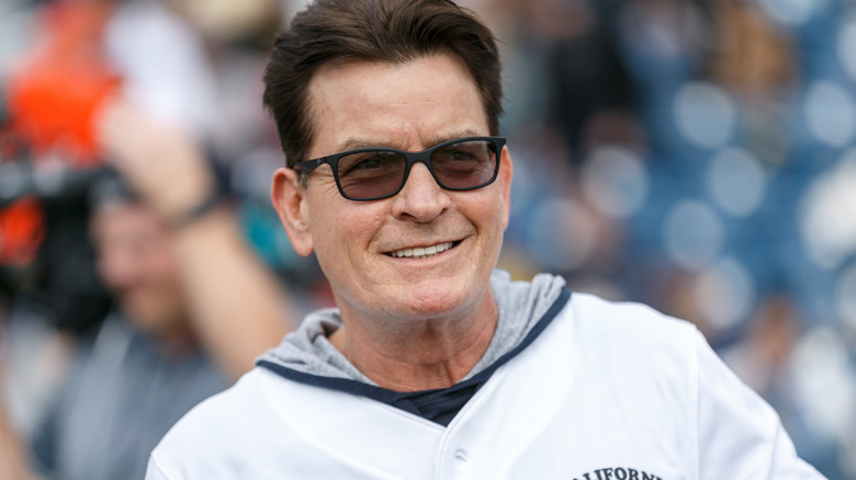 Charlie Sheen smiling sunglasses white hoodie