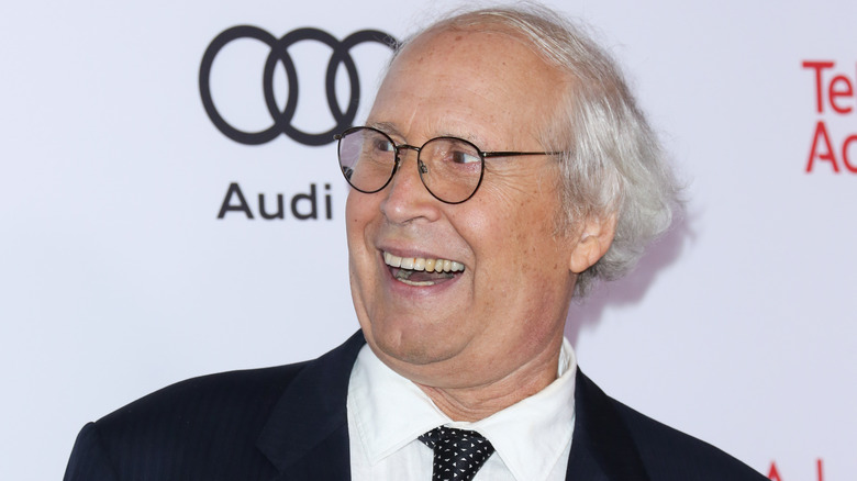 Chevy Chase laughing suit glasses at event