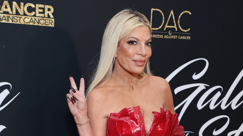 Tori Spelling flashing the peace sign on the red carpet at Dancers Against Cancer event