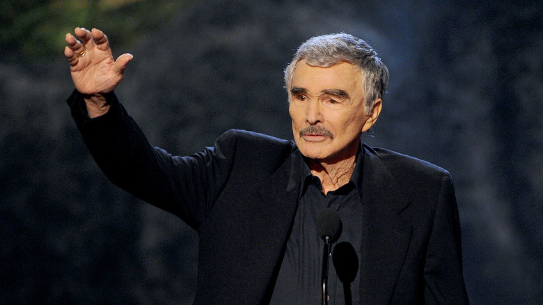 Burt Reynolds waving from stage