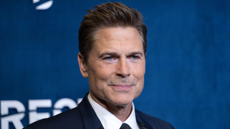 Rob Lowe smiling against blue background