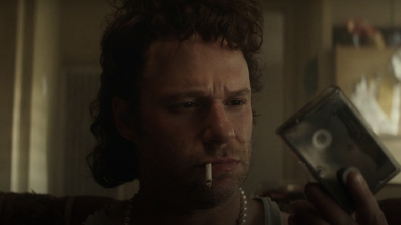 Seth Rogen as Rand Gauthier holding tape
