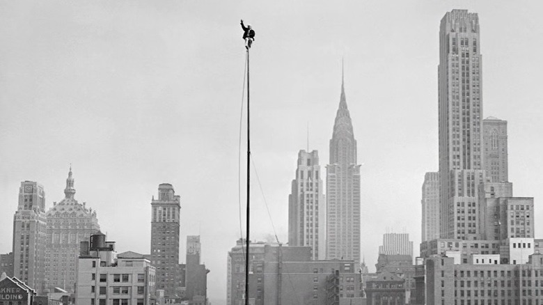 man sitting on top of pole