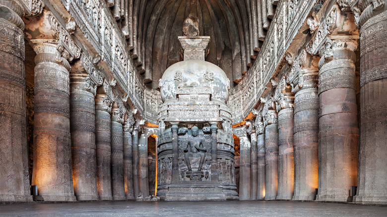 Carved stone hallway with stone pillars and sculptures.