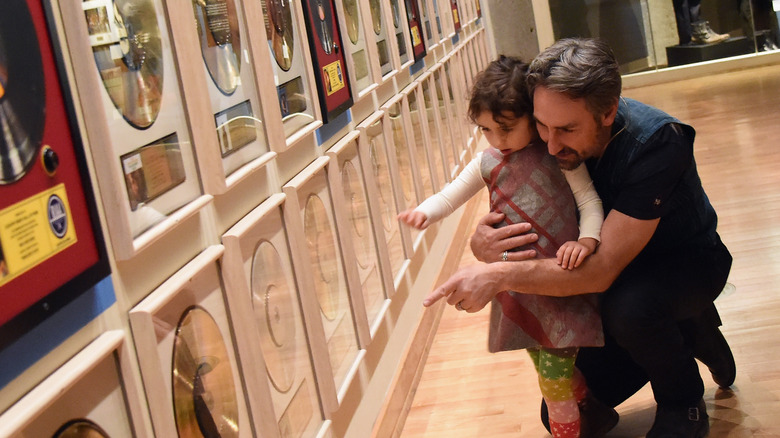 Mike Wolfe with daughter Charlie pointing at records