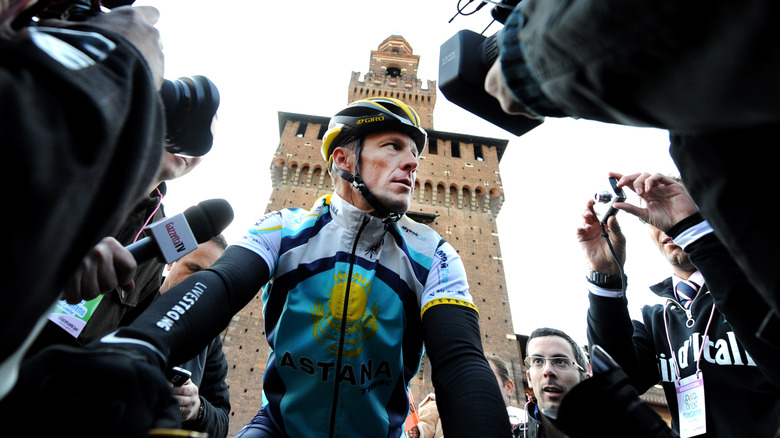 Lance Armstrong surrounded by reporters