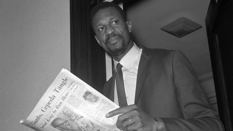 Bill Russell holding newspaper