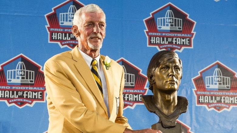 Ray Guy holding bust