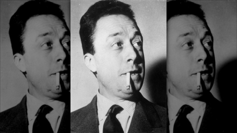 Albert Camus in suit smoking cigarette