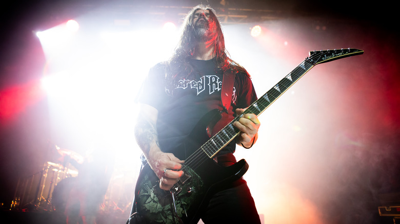 Andreas Kisser looking up playing guitar on stage