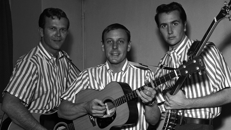 The Kingston Trio posing with guitars striped shirts