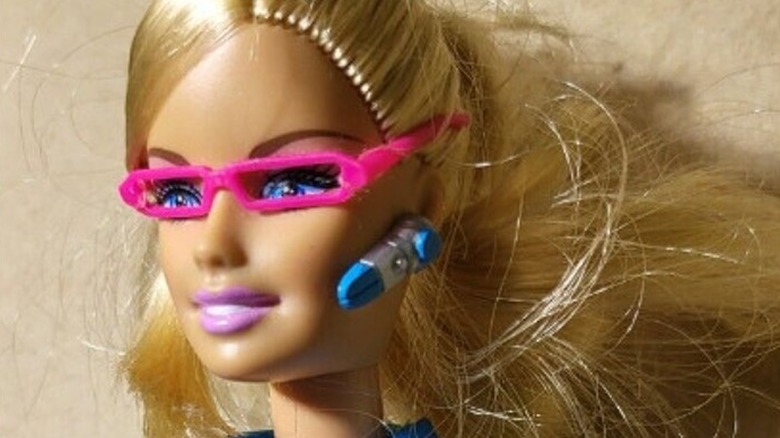Close-up of Barbie wearing pink glasses and a Bluetooth headset