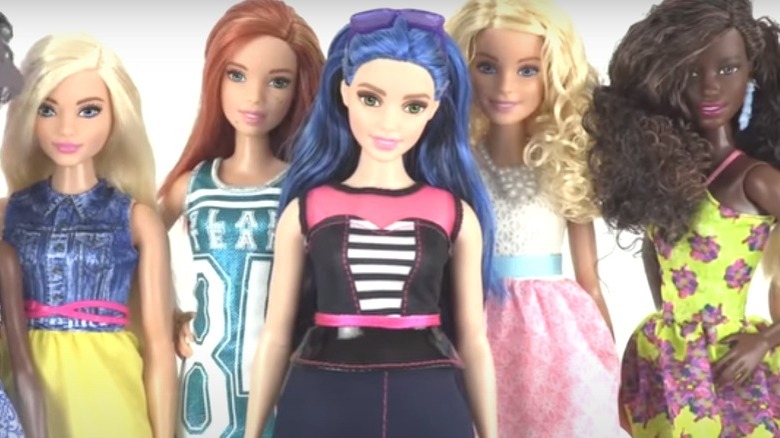 Five Barbie dolls of different body types with the blue-haired curvy doll in front