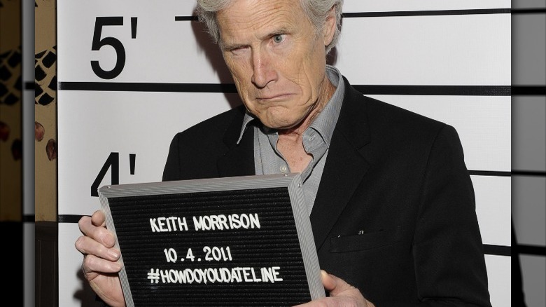 Keith Morrison grimacing with lineup screen holding name plaque