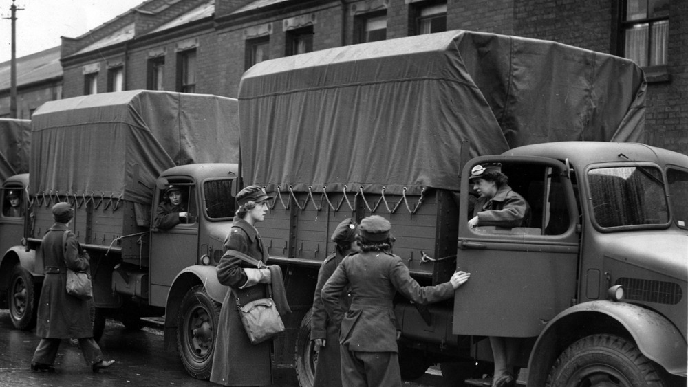 Military trucks with military women getting in 